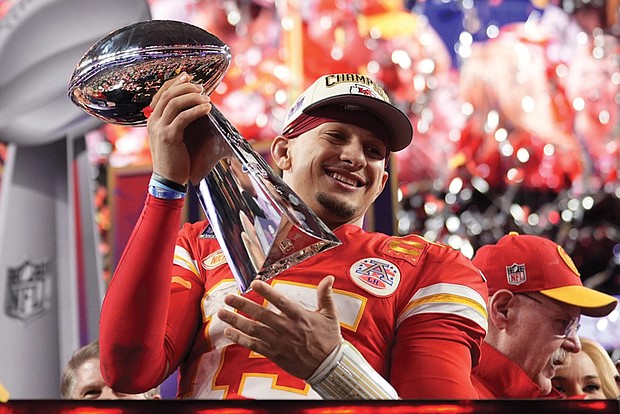 Kansas City Chiefs quarterback Patrick Mahomes celebrates with the trophy Sunday after the team’s overtime win during Super Bowl LVIII against the San Francisco 49ers in Las Vegas. Behind him is Kansas City Chiefs Coach Andy Reid. The Chiefs won 25-22.