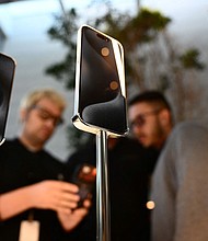 Apple iPhone 15 series devices are displayed for sale as a customer purchases an iPhone at The Grove Apple retail store on release day in Los Angeles, California, on September 22, 2023.
Mandatory Credit:	Patrick T. Fallon/AFP/Getty Images