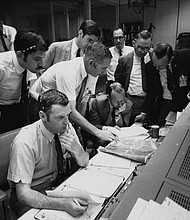 Flight controllers gather around NASA Flight Director Glynn Lunney (seated, foreground) in the control room at what's now called Johnson Space Center in Houston during the Apollo 13 aborted lunar landing mission, on April 15, 1970.
Mandatory Credit:	Space Frontiers/Archive Photos/Getty Images via CNN Newsource