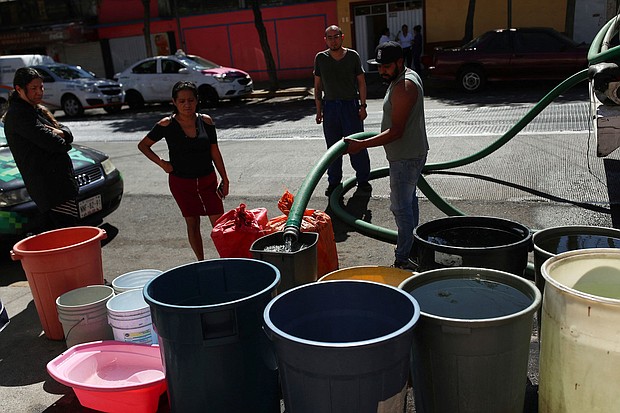 People fill buckets from a water tanker in the Azcapotzalco neighborhood in Mexico City on January 26.
Mandatory Credit:	Henry Romero/Reuters via CNN Newsource