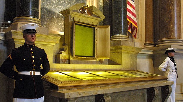 In this file photo, an honor guard stands next to the Declaration of Independence, the Constitution, and the Bill of Rights in the National Archives in Washington, DC. Two people were charged after they allegedly dumped red powder over the display case.
Mandatory Credit:	Alex Wong/Getty Images/File via CNN Newsource