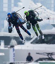 In what's being billed as the world's first-ever jet suit race, two of the competing eight pilots fly against a backdrop of skyscrapers and luxury yachts in Dubai on February 28.
Mandatory Credit:	Jon Gambrell/AP via CNN Newsource