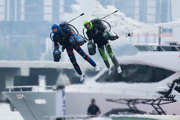 In what's being billed as the world's first-ever jet suit race, two of the competing eight pilots fly against a backdrop of skyscrapers and luxury yachts in Dubai on February 28.
Mandatory Credit:	Jon Gambrell/AP via CNN Newsource
