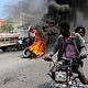 People drive past a burning blockade as demonstrators hold a protest calling for the resignation of Haitian Prime Minister Ariel Henry outside the Canadian Embassy, in Port-au-Prince, Haiti, February 25.
Mandatory Credit:	Ralph Tedy Erol/Reuters via CNN Newsource