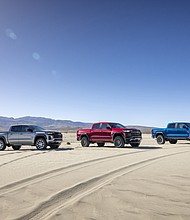 From right to left: pack shot of Colorado Z71, Trail Boss and ZR2 in sandy dessert.