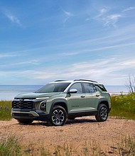 Front 3/4 view of a 2025 Chevrolet Equinox ACTIV in Cacti Green parked in front of a lake. Preproduction model shown. Actual production model may vary. Model year 2025 Chevrolet Equinox available 2024.