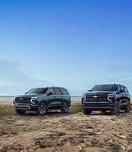 Group shot of 2025 Tahoe Z71 (left) and 2025 Suburban High Country shown on the beach