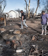 Tia Champion and her husband Tim help a friend search the remains of her home near Stinnett, Texas, after it was destroyed by the Smokehouse Creek Fire.
Mandatory Credit:	Scott Olson/Getty Images via CNN Newsource