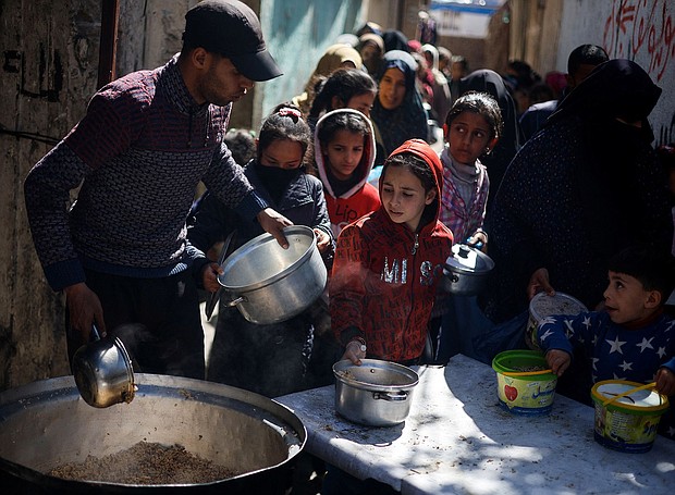 Palestinian children wait to receive food cooked by a charity kitchen amid shortages of food supplies amid the conflict between Israel and Hamas in Rafah, in the southern Gaza Strip, on March 5.
Mandatory Credit:	Mohammed Salem/Reuters via CNN Newsource
