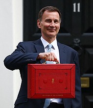 UK finance minister Jeremy Hunt poses with the red budget box outside his office on Downing Street in London on March 6.
Mandatory Credit:	Hannah McKay/Reuters via CNN Newsource