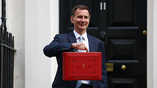 UK finance minister Jeremy Hunt poses with the red budget box outside his office on Downing Street in London on March 6.
Mandatory Credit:	Hannah McKay/Reuters via CNN Newsource