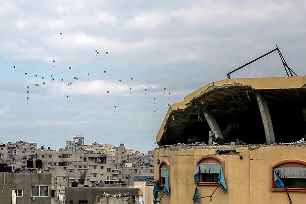 Aid parcels are airdropped over the northern Gaza Strip on Friday.
Mandatory Credit:	AFP/Getty Images via CNN Newsource
