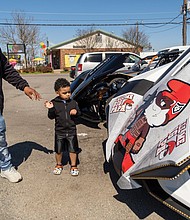 DeAndre Smith and his son, Nuri Harris, 3, take a look at some of the Sling Shots from visiting riders attending the ribbon-cutting ceremony on the lot of Hot Wheelz Sling Shot Rentals.