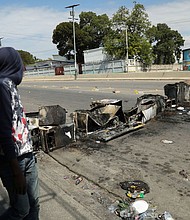 A man passes a barricade consumed by fire amid Haiti's state of emergency, in Port-au-Prince on Wednesday, March 6.
Mandatory Credit:	Ralph Tedy Erol/Reuters/File via CNN Newsource