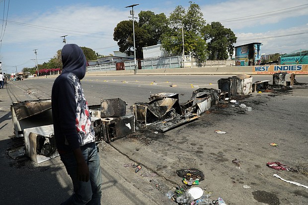 A man passes a barricade consumed by fire amid Haiti's state of emergency, in Port-au-Prince on Wednesday, March 6.
Mandatory Credit:	Ralph Tedy Erol/Reuters/File via CNN Newsource