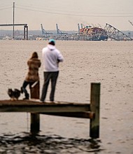 Onlookers check out the Francis Scott Key Bridge following its collapse early Tuesday in Baltimore.
Mandatory Credit:	Kent Nishimura/AFP/Getty Images via CNN Newsource