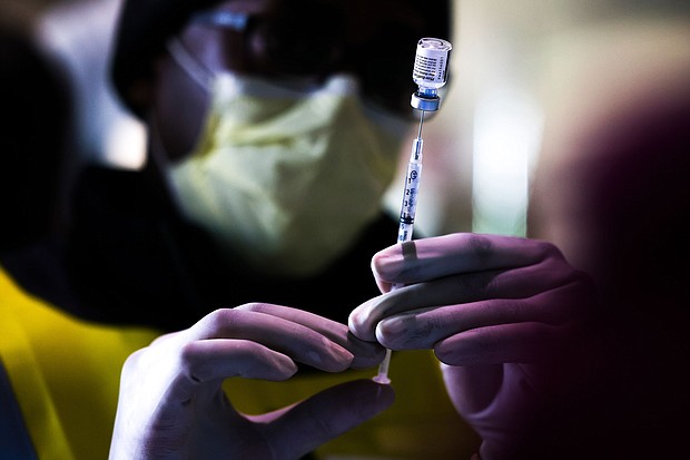 Pharmacy technicians prepare doses of the Pfizer-BioNTech vaccine at a mass COVID-19 vaccination event on January 30, 2021 in Denver, Colorado. By using mRNA vaccine tech developed over decades, pharmaceutical companies like Pfizer and Moderna made a windfall in profits.
Mandatory Credit:	Michael Ciaglo/Getty Images via CNN Newsource