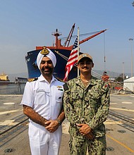 Seaman Adam Sindhu (right) poses with a sailor
from a foreign navy during Exercise MILAN 2024.
(U.S. Navy photo)