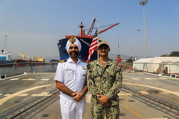Seaman Adam Sindhu (right) poses with a sailor
from a foreign navy during Exercise MILAN 2024.
(U.S. Navy photo)