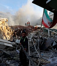 Emergency services work at a destroyed building hit by an air strike in Damascus, Syria, Monday, April 1.
Mandatory Credit:	Omar Sanadiki/AP via CNN Newsource