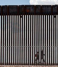 Migrants walk along the Mexico-US border after the the Republican-backed Texas law known as SB 4 took effect on March 19.
Mandatory Credit:	Justin Hamel/Reuters via CNN Newsource
