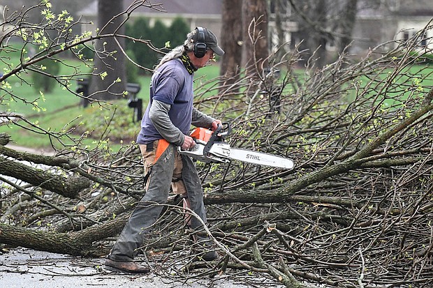 A worker cut up downed tress lying across the road following severe storms that passed through Prospect, Kentucky, Tuesday, April 2.
Mandatory Credit:	Timothy D. Easley/AP via CNN Newsource