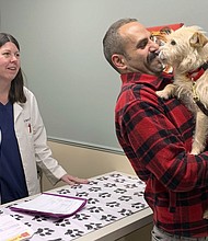 Mehrad Houman of San Diego holds Mishka after the dog was examined Friday by veterinarian Nancy Pillsbury in Harper Woods, Mich.
Mandatory Credit:	Corinne Martin/AP via CNN Newsource