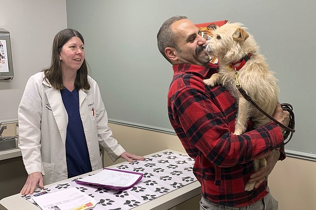 Mehrad Houman of San Diego holds Mishka after the dog was examined Friday by veterinarian Nancy Pillsbury in Harper Woods, Mich.
Mandatory Credit:	Corinne Martin/AP via CNN Newsource