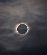 A total solar eclipse is visible through thin clouds as seen from Vágar on the Faroe Islands, Friday, March 20, 2015.
Mandatory Credit:	Eric Adams/AP via CNN Newsource