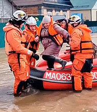 Emergency workers evacuate a local resident after a part of a dam burst causing flooding, in Orsk, Russia.
Mandatory Credit:	Russian Emergency Ministry Press Service via AP via CNN Newsour