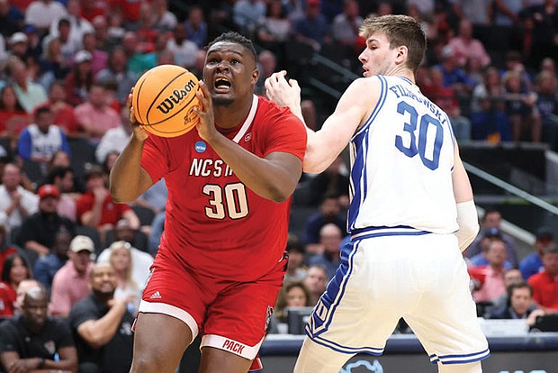 DJ Burns drives past Duke’s Kyle Filipowski and leads North Carolina State into the Final Four.