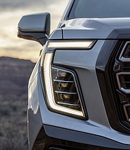 Exterior view of the 2025 GMC Yukon AT4, showcasing its refreshed front fascia, updated headlight and redesigned grille executions.