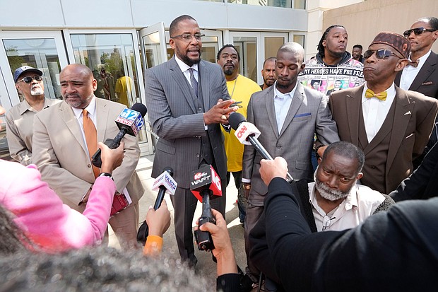 Attorney Malik Shabazz, center, speaks outside the federal courthouse in Jackson, Mississippi, after a sentencing hearing in March as his client, Michael Jenkins, listens.
Mandatory Credit:	Rogelio V. Solis/AP via CNN Newsource