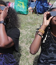 Cousins Mary Bitki, 30, left, and Angella Akita, 18, both of Richmond, sported stylish protective eyewear to view the historic partial solar eclipse. The next solar eclipse will be in 20 years.