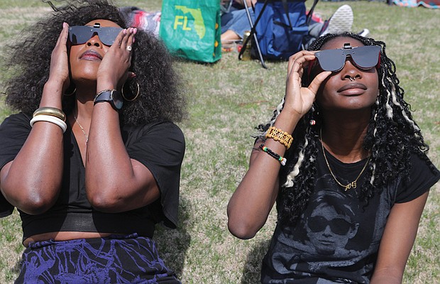 Cousins Mary Bitki, 30, left, and Angella Akita, 18, both of Richmond, sported stylish protective eyewear to view the historic partial solar eclipse. The next solar eclipse will be in 20 years.