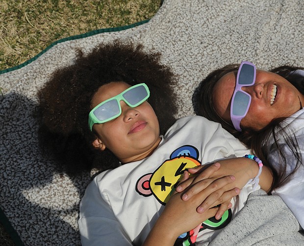 Lila Hunter, 10, of Newport News, left, had a day off from school, which she used to take in the historic partial solar eclipse with her aunt, Dawn Leigh Anderson, of Louisa County. They were among hundreds of other spectators on the front lawn of the Science Museum to see the partial eclipse.