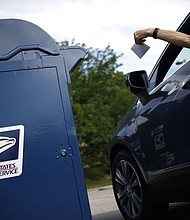 A motorist drops a letter into a USPS mail drop box at a post office in Kentucky in 2022.
Mandatory Credit:	Luke Sharrett/Bloomberg/Getty Images via CNN Newsource