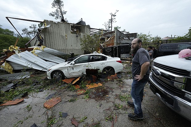 People survey a severely damaged business in Slidell, Louisiana, after severe storms swept through on Wednesday.
Mandatory Credit:	Gerald Herbert/AP via CNN Newsource