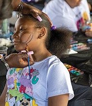 Tamira, 10, gets her face painted at the COLOR Carnival at Bryan Park The event, held across Virginia, offers family activities and resources, including community baby showers. Created by Kenda Sutton-el in 2019 during Black Maternal Health Week, the carnival aims to entertain children while educating mothers about maternal mortality.