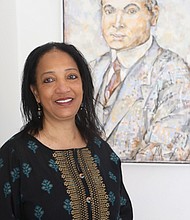 Zarina Fazaldin poses for a portrait in the home that she bought, restored and now celebrates at 508 St. James St., in Historic Jackson Ward. The home originally was commissioned in 1915 for Dr. William Henry Hughes, pictured in a painting behind her, by Black architect Charles T. Russell.