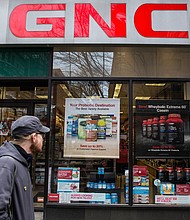In this 2015 file photo, people walk past a GNC store on March 30, 2015 in New York City.
Mandatory Credit:	Andrew Burton/Getty Images/File via CNN Newsource