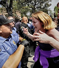 A University of Southern California protester, right, confronts a University Public Safety officer at the campus' Alumni Park during a pro-Palestinian occupation Wednesday in Los Angeles.
Mandatory Credit:	Richard Vogel/AP via CNN Newsource