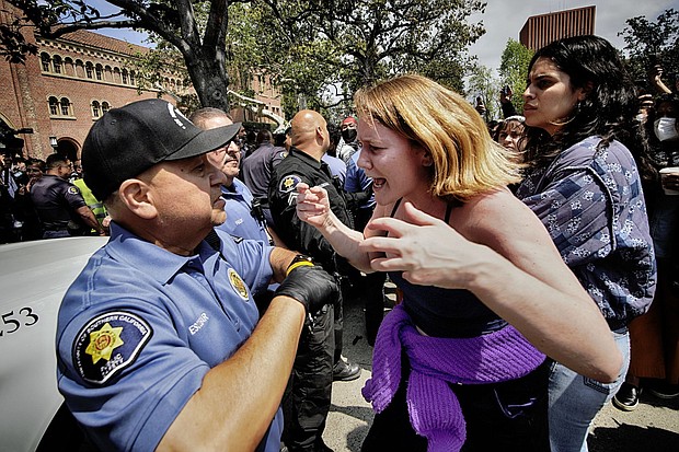 A University of Southern California protester, right, confronts a University Public Safety officer at the campus' Alumni Park during a pro-Palestinian occupation Wednesday in Los Angeles.
Mandatory Credit:	Richard Vogel/AP via CNN Newsource