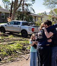 Neighbors embrace Penny Thomsen outside of her home after multiple tornadoes ripped across the state the evening before, in the Des Moines suburb of Pleasant Hill, Iowa, Saturday, April 27.
Mandatory Credit:	Zach Boyden-Holmes/USA Today/Reuters via CNN Newsource