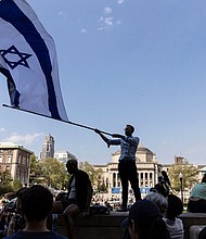 A student waves an Israeli flag outside the protest encampment on the Columbia University campus in New York City on April 29.
Mandatory Credit:	Stefan Jeremiah/AP via CNN Newsource