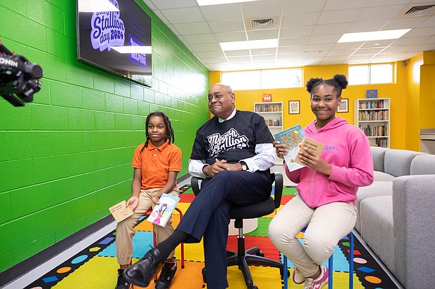 Harris County Commissioner Rodney Ellis, center, smiles as Reese Norman, 9, left, and Kimorre Miles, 9, hold books at the Finnigan Youth Education Town’s renovated Literacy Room, thanks to a $35,000 donation from Megan Thee Stallion’s nonprofit Pete & Thomas Foundation.