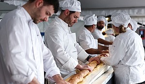 French bakers try not to crack the baguette when it comes out of a large rotating oven.
Mandatory Credit:	Stephanie Lecocq/Reuters via CNN Newsource