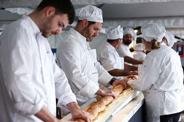French bakers try not to crack the baguette when it comes out of a large rotating oven.
Mandatory Credit:	Stephanie Lecocq/Reuters via CNN Newsource