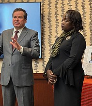 Caroline Ouko (left), the mother of 28-year-old Irvo Otieno, listens as her attorney, Mark Krudys, responds to Commonwealth Attorney Amanda Mann’s decision to dismiss charges against five of the eight criminal defendants charged with Mr. Otieno’s murder. Ms. Ouko also is represented by attorney Ben Crump, who spoke virtually at the press conference.