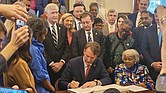 Gov. Glenn Youngkin signs the budget with state Sen. L. Louise Lucas, D-Portsmouth, seated to his left, on Monday, May 13.